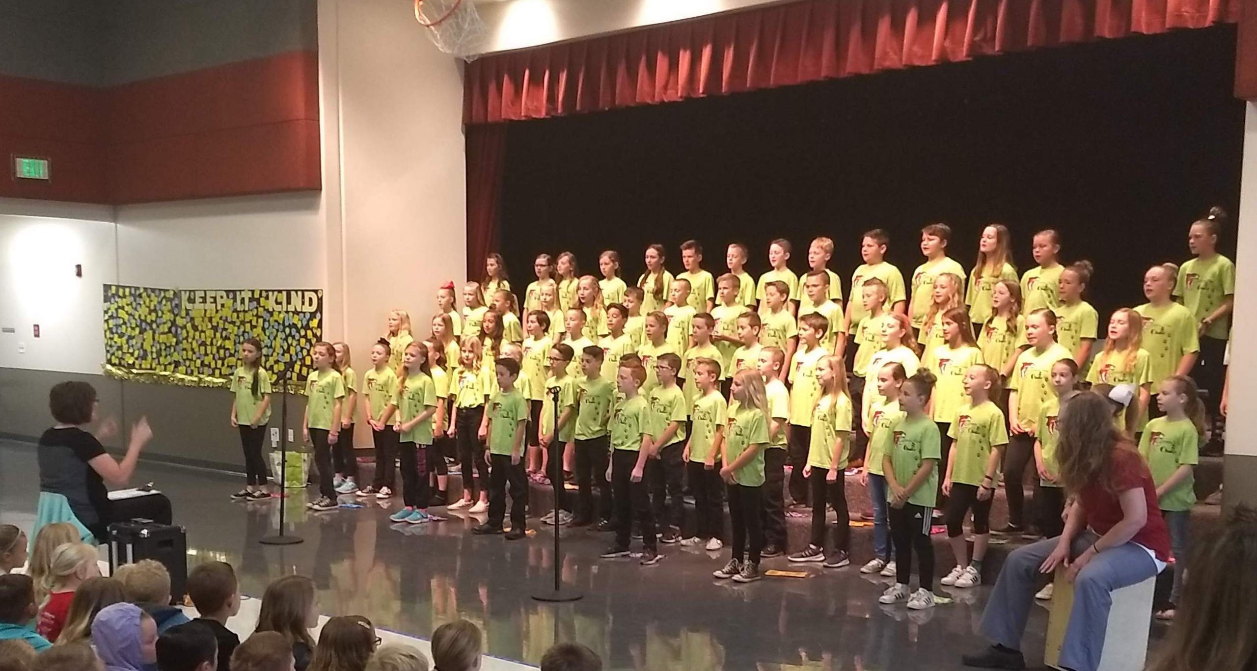 Choir in yellow shirt singing on stage