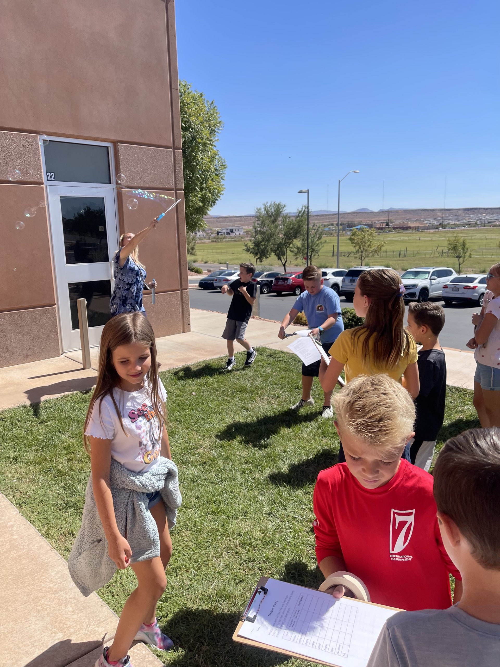 Students and teacher outside with bubbles.
