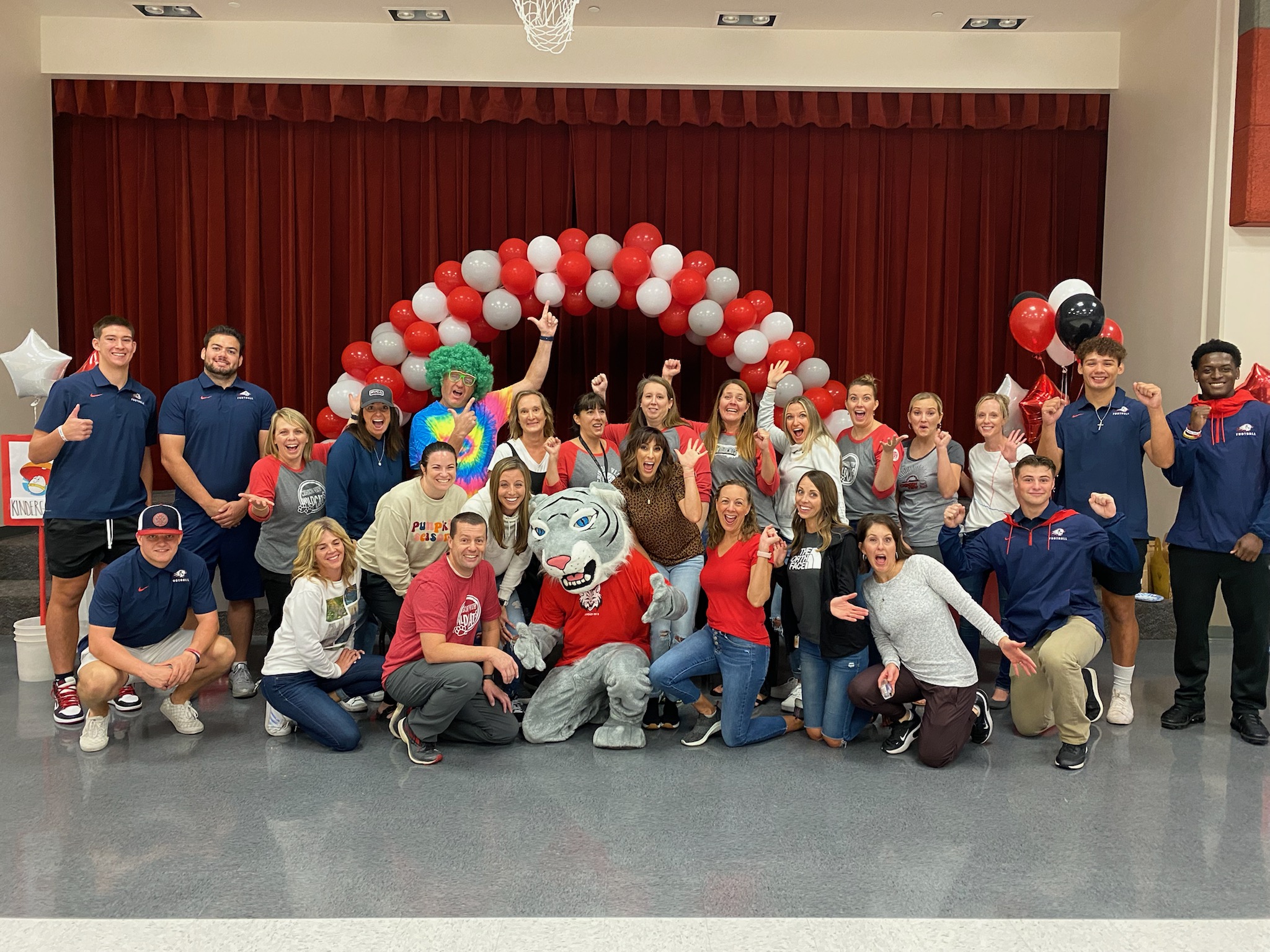 Dixie State athletes and school staff taking a group photo with school mascot. 