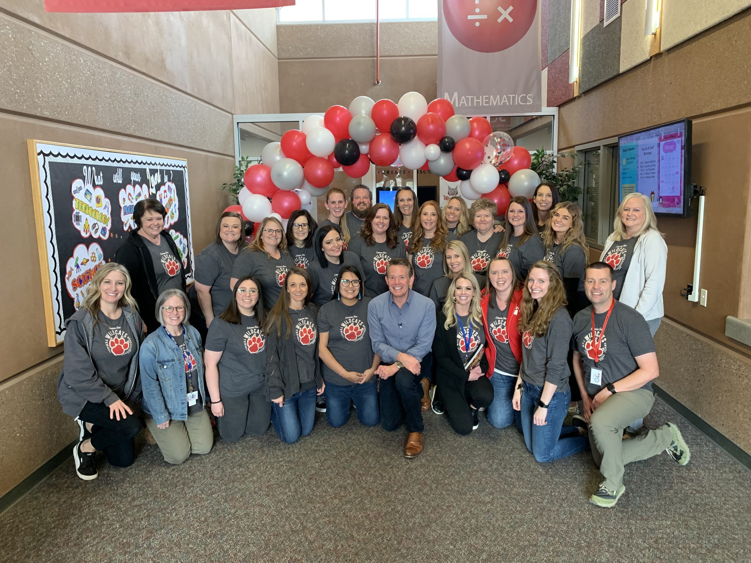 faculty picture posing with steve spangler in entry of school